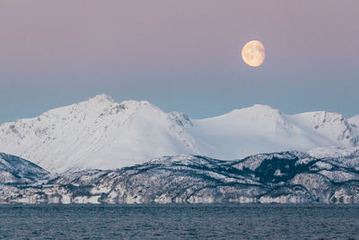 Scenic view of snowcapped mountains against sky at night