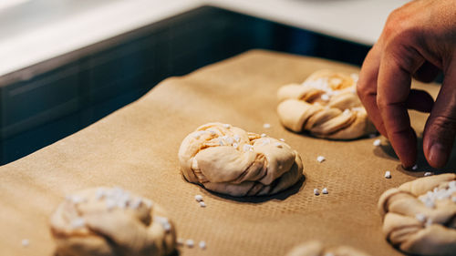 Midsection of person holding cookies on table