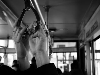 Close-up of hands holding handles in the train