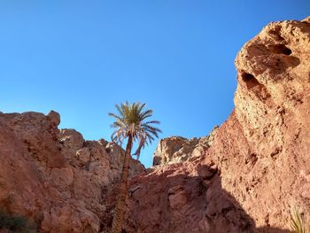 Low angle view of rock formation against clear blue sky