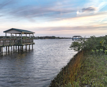 House by sea against sky during sunset