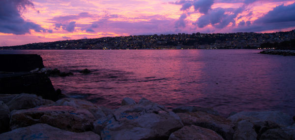 Scenic view of sea against dramatic sky during sunset