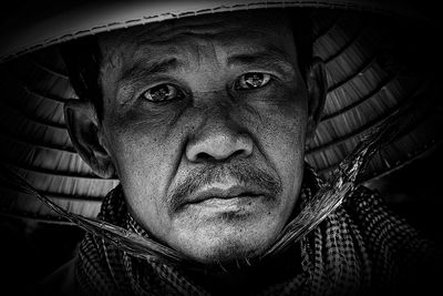 Close-up portrait of man in asian style conical hat