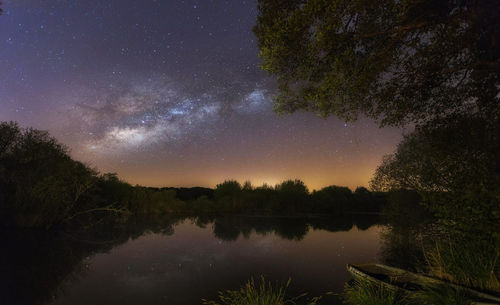 Scenic view of lake against sky at night