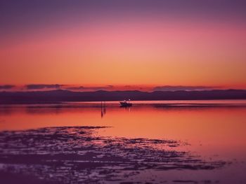 Scenic view of sea against orange sky