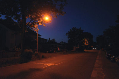 Street amidst buildings against sky at night