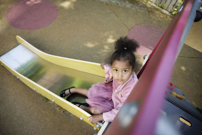 Portrait of girl having fun on slide in playground