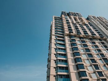 Low angle view of skyscraper against clear blue sky