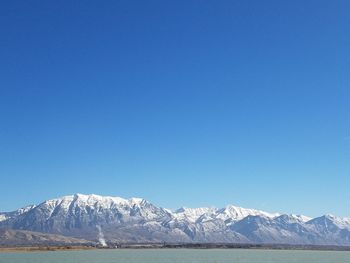 Scenic view of snowcapped mountains against clear blue sky