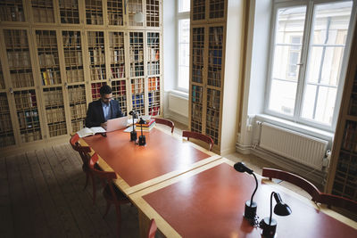 Male professional researching at table in law library