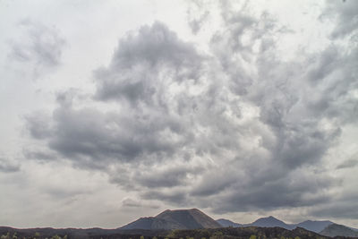 Scenic view of mountains against cloudy sky