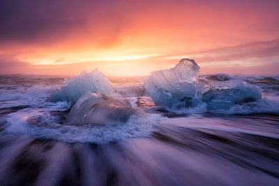 Scenic view of frozen sea against sky during sunset