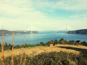 Suspension bridge over sea against sky