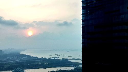 Buildings in city against sky during sunset