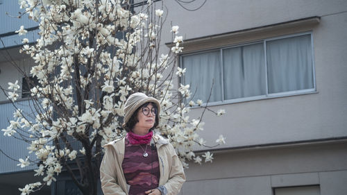 Portrait of woman standing against building