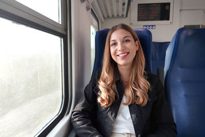 Portrait of young satisfied woman traveling with public transport sitting relaxed thoughtless.