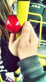 Close-up of hand holding yellow object