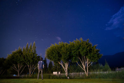 Trees on field against sky at night