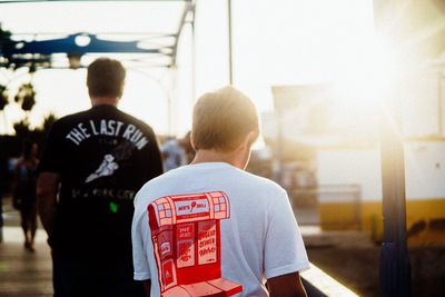 Rear view of people walking by building