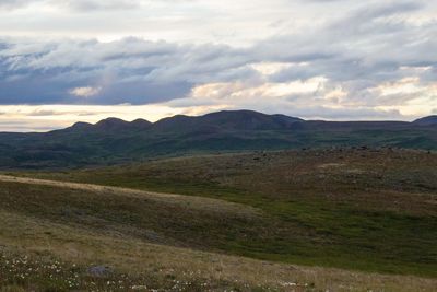 Scenic view of mountains against cloudy sky