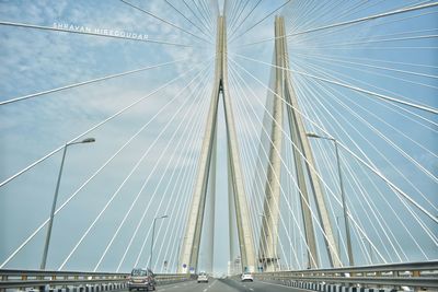 Low angle view of suspension bridge against sky