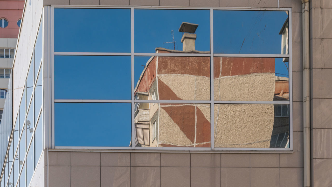 LOW ANGLE VIEW OF GLASS WINDOW ON BUILDING