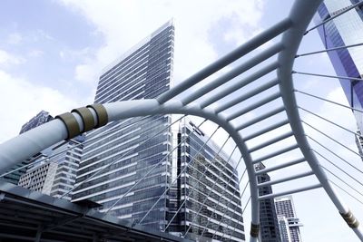 Low angle view of modern buildings against sky. elevated skywalk in the heart of bangkok,thailand.