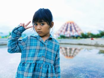 Portrait of boy standing against water