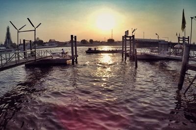 Boats in harbor at sunset