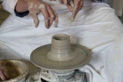 Hands making pottery