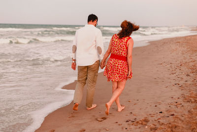 Rear view of couple on beach