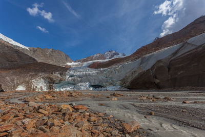 Vallelunga glacier collapsing tongue with ice caves and turbid stream, italy