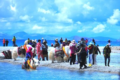 People at beach against sky