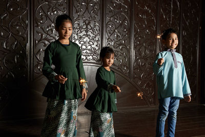 Malay siblings playing fireworks sparkler during ramadan festival 