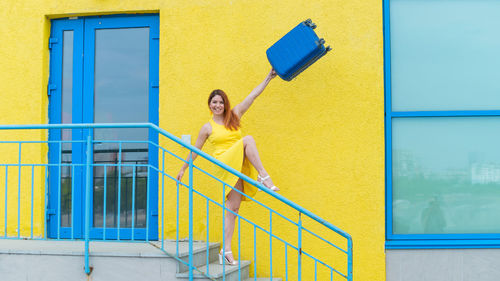 Woman standing by yellow railing