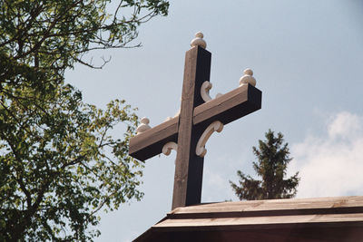 Low angle view of cross against sky