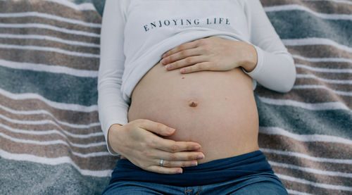 Midsection of woman touching mannequin