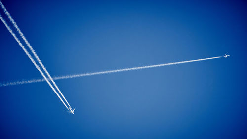 Low angle view of vapor trail against blue sky