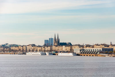 Buildings in city against cloudy sky