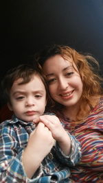 Portrait of smiling mother with son at home