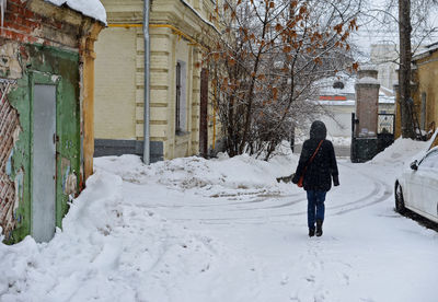 Rear view of man walking in snow