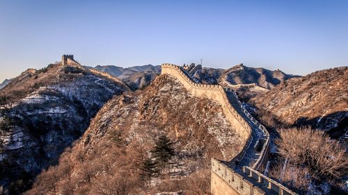 Panoramic view of mountain range against clear sky with great wall of china crossing the ridges