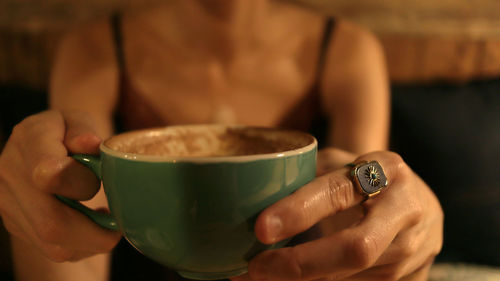 Midsection of woman holding coffee cup