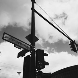 Low angle view of road sign against cloudy sky