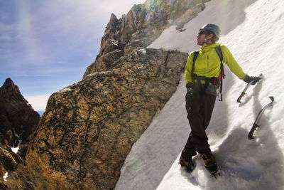 Ice climber looking away while standing on mountain