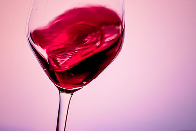 Close-up of red wine glass against white background