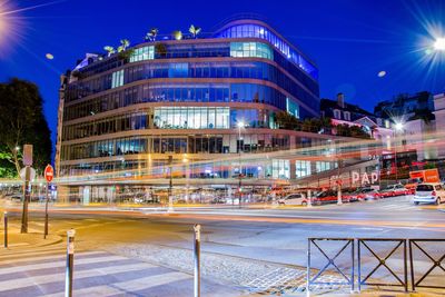 Light trails on street against buildings at night