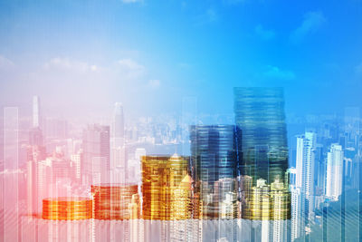 Panoramic view of buildings in city against blue sky