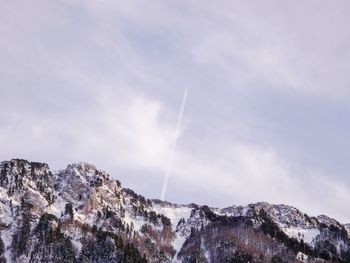 Low angle view of snowcapped mountains against sky