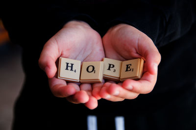 Close-up of hand holding text hope wish